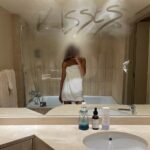 Minimalist skincare routine mirror selfie with Vichy and SPF in a luxury bathroom – SkinTrends.eu