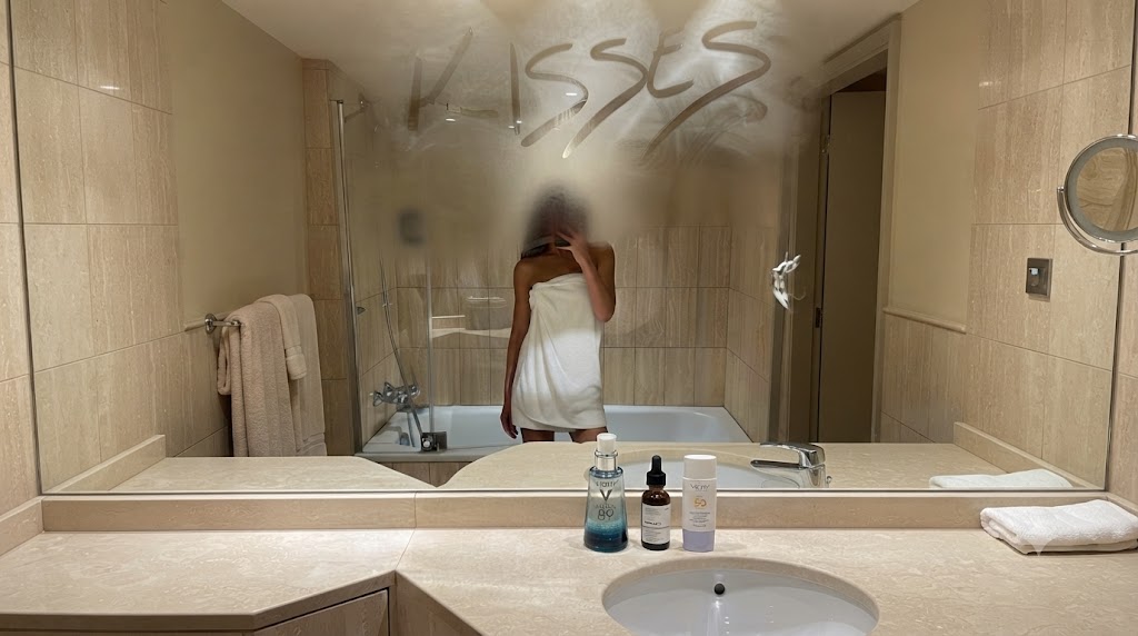 Minimalist skincare routine mirror selfie with Vichy and SPF in a luxury bathroom – SkinTrends.eu